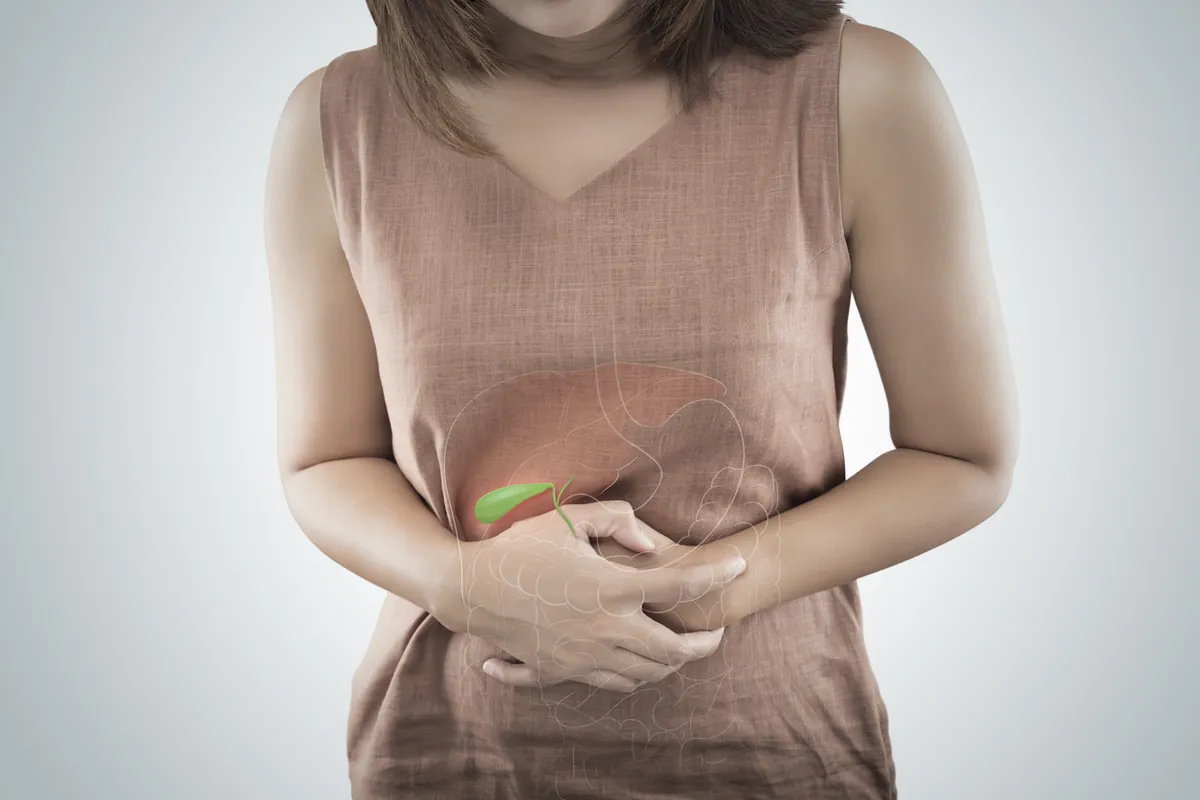 A woman holding the upper right side of her abdomen, with the liver and gallbladder shown over it